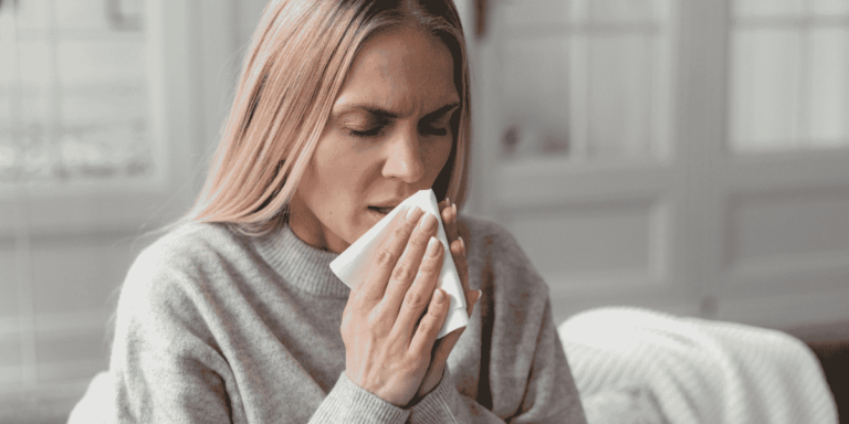 Woman sneezing at home