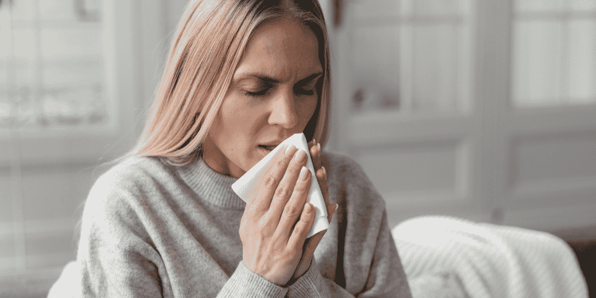 Woman sneezing at home