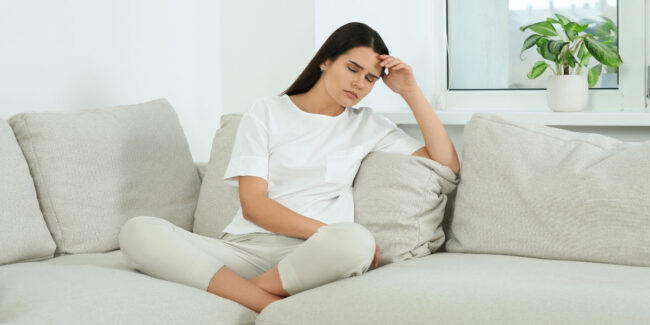 Stressed woman sitting on sofa
