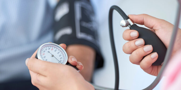 Doctor checking blood pressure of patient