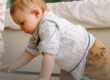 Toddler playing with large wooden blocks under parent supervision in a safe home setting.