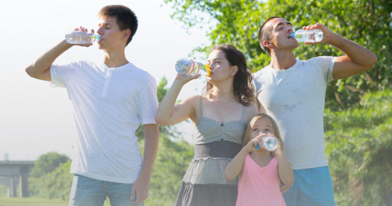 Family drinking water during a summer outdoor activity- Staying hydrated before, during, and after outdoor activities can help prevent dehydration and heat-related illness.