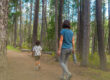 Parent and child walking on a forest trail during tick season, promoting outdoor safety and Lyme disease prevention.