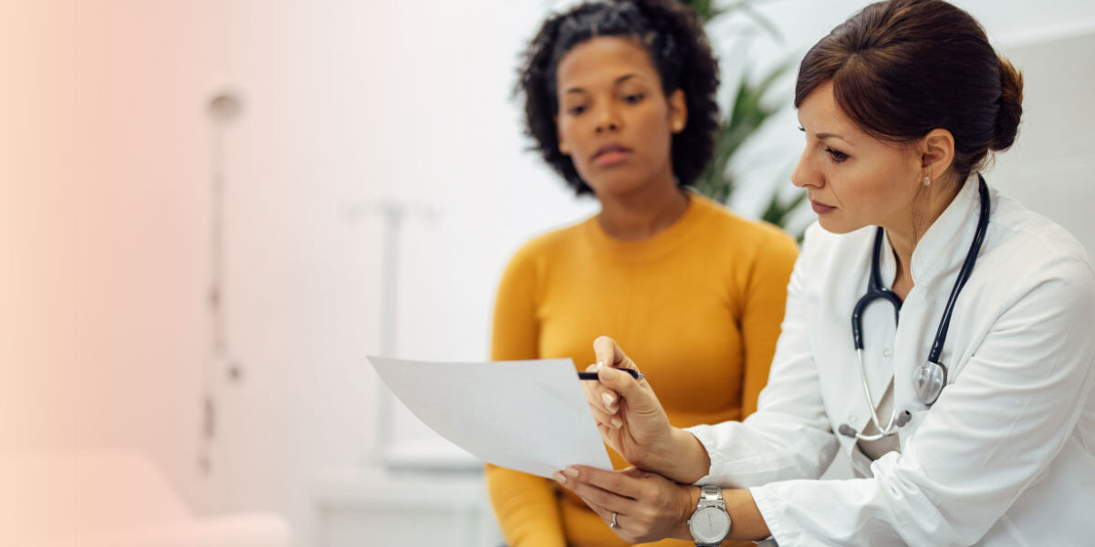 Doctor reviewing medical test results with a female patient during a healthcare consultation.