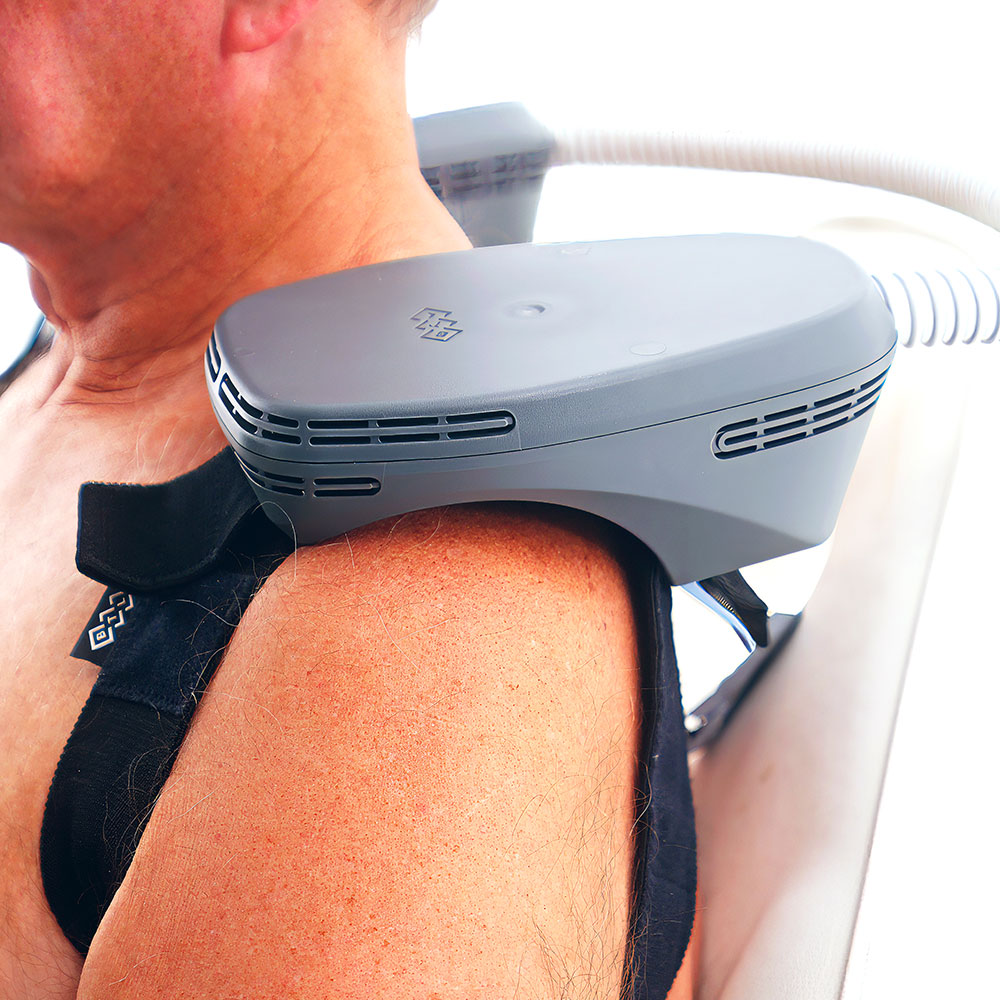 EMSCULPT NEO applicator positioned on a patient's shoulder during muscle stimulation treatment.