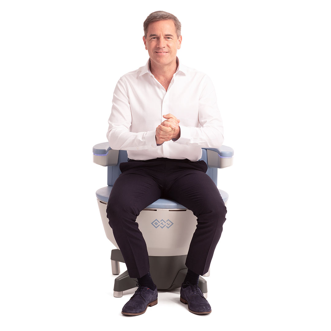 Man seated fully clothed on an EMSELLA chair for noninvasive pelvic floor therapy.